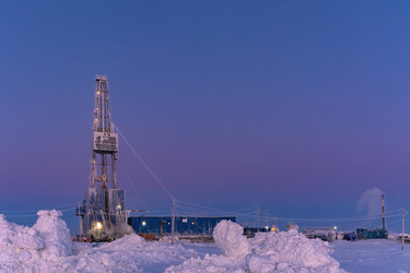 зимний вид работающей буровой установки для добычи нефти и газа, покрытой снегом, в суровых арктических условиях во время полярных сумерек. прекрасное пурпурное небо - Vkadimir