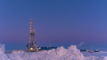 зимний вид работающей буровой установки для добычи нефти и газа, покрытой снегом, в суровых арктических условиях во время полярных сумерек. прекрасное пурпурное небо - Vkadimir