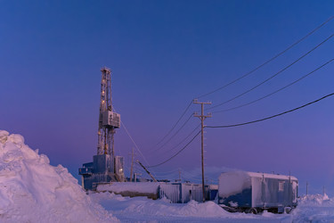 зимний вид работающей буровой установки для добычи нефти и газа, покрытой снегом, в суровых арктических условиях во время полярных сумерек. прекрасное пурпурное небо - Vkadimir