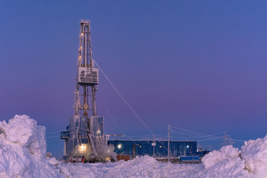 зимний вид работающей буровой установки для добычи нефти и газа, покрытой снегом, в суровых арктических условиях во время полярных сумерек. прекрасное пурпурное небо - Vkadimir