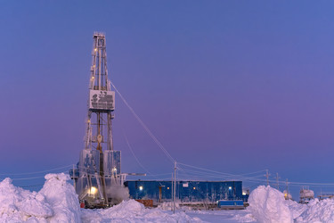 зимний вид работающей буровой установки для добычи нефти и газа, покрытой снегом, в суровых арктических условиях во время полярных сумерек. прекрасное пурпурное небо - Vkadimir