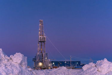 зимний вид работающей буровой установки для добычи нефти и газа, покрытой снегом, в суровых арктических условиях во время полярных сумерек. прекрасное пурпурное небо - Vkadimir