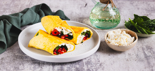вкусные роллы с фетой, жареным болгарским перцем и шпинатом на тарелке на веб-баннере "стол" - Elena Rui
