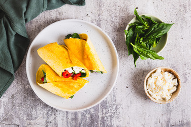вкусные рулетики с фетой, жареным болгарским перцем и шпинатом на тарелке на столе вид сверху - Elena Rui