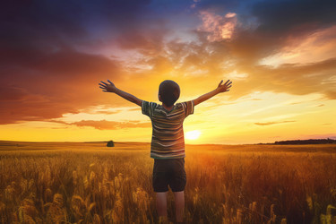 Boy with raised hand admiring sunset in wheat field. Happy child enjoying sundown fiery lights. Generate ai - yliv