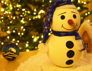 прекрасный снеговик в синей шапочке и с дружелюбной улыбкой на лице, стоящий рядом с елкой. игрушка, подходящая в качестве подарка или для праздничного декора на новый год или рождество. излучающий тепло и доброту - Dimasik_85