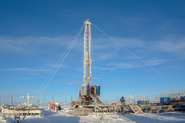 установка для капитального ремонта нефтяных и газовых скважин, работающая в суровых условиях арктической зимы. промышленный пейзаж с тяжелой техникой, заснеженной вечной мерзлотой и солнечным ясным полярным днем - Vkadimir