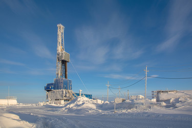 покрытая инеем буровая установка для бурения нефтяных и газовых скважин работает в экстремальных зимних условиях арктики в течение яркого полярного дня. окруженный глубоким снегом и ясным голубым небом - Vkadimir