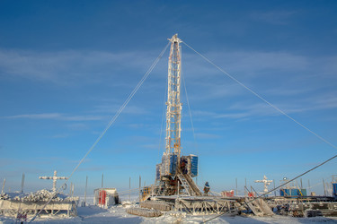 установка для капитального ремонта нефтяных и газовых скважин, работающая в суровых условиях арктической зимы. промышленный пейзаж с тяжелой техникой, заснеженной вечной мерзлотой и солнечным ясным полярным днем - Vkadimir