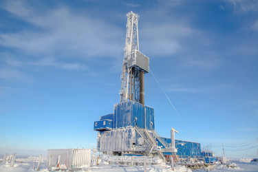 покрытая инеем буровая установка для бурения нефтяных и газовых скважин работает в экстремальных зимних условиях арктики в течение яркого полярного дня. окруженный глубоким снегом и ясным голубым небом - Vkadimir