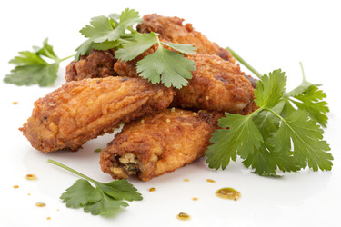 вкусные жареные куриные крылышки, украшенные свежей кинзой на тарелке - RomanZ