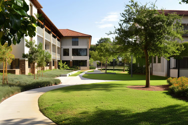 Lush green space is featured in the courtyard of a modern university campus building - yliv