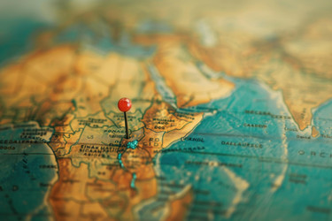 Red push pin marking a location on a world map - yliv