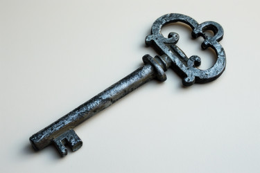 Old worn antique key is lying on a white background, representing concepts such as history, security, and mystery - yliv