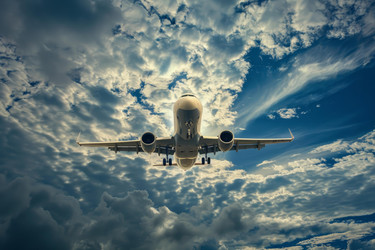 Passenger airplane is flying high in the sky towards a dramatic cloudscape - yliv