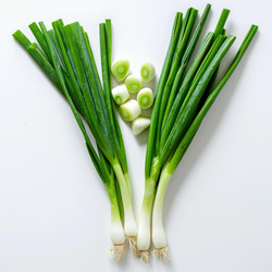 Fresh green onions with a few slices arranged on a white background - yliv