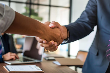 Business partnership concept with two businessmen shaking hands after successful meeting in office - yliv
