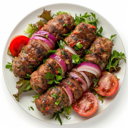 Delicious cevapcici with onions and tomatoes served on white plate with fresh vegetables - yliv