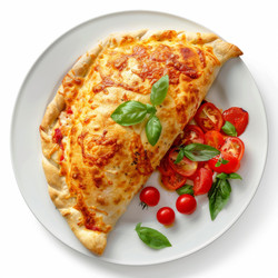 вкуснейшая закрытая пицца кальцоне с помидорами и базиликом на белой тарелке - yliv
