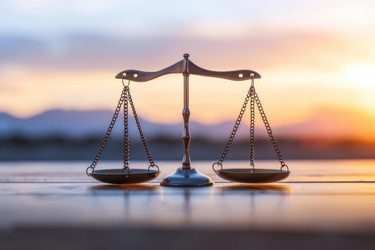 Balancing scales of justice at sunset symbolizing legal system, law, fairness, equality, and justice - yliv