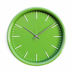 Green wall clock showing five minutes past twelve on white background - yliv