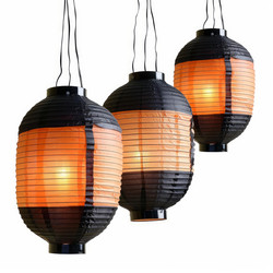 Three illuminated orange and black paper lanterns hanging on white background - yliv