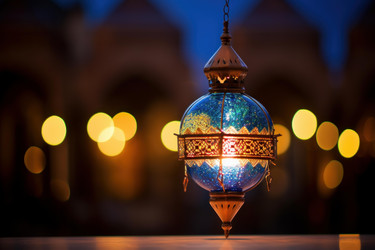 Hanging arabic lantern illuminating the night with bokeh lights in background - yliv