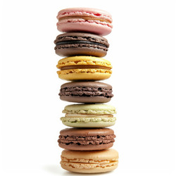 Красочные macarons сложены на белом фоне, создавая вкусный башня - yliv