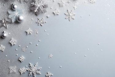 Silver and white snowflakes and ornaments creating festive atmosphere on light blue background - yliv