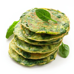 вкусные блинчики со шпинатом, выложенные высокой стопкой и украшенные свежими листьями шпината, создают яркий и полезный вариант завтрака - yliv