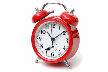 Red alarm clock on a white background measuring time passing - yliv