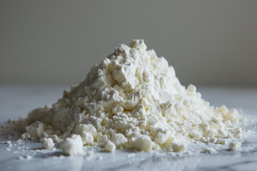 Pile of flour forming a small mountain on marble surface - yliv