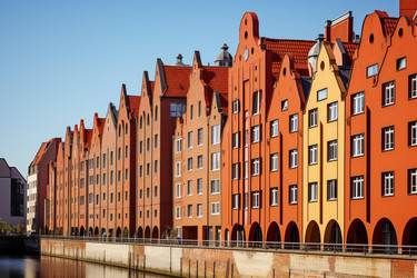 Colorful facades of historic granaries reflecting on the motlawa river in gdansk, poland - yliv