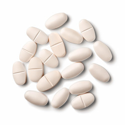 Oval white pills with a dividing line forming a circular pattern on a white background, ideal for pharmaceutical or healthcare related themes - yliv