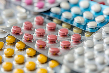 на столе лежат блистерные упаковки с разноцветными медицинскими таблетками - yliv