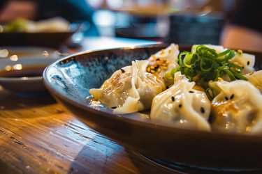 вкусные клецки геза подаются в миске, украшенные семенами кунжута и зеленым луком, готовые к употреблению. - yliv