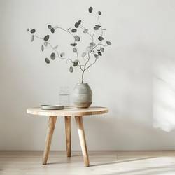 Eucalyptus branches, ceramic vase, and glass bottle resting on wooden table in minimalist interior design - yliv