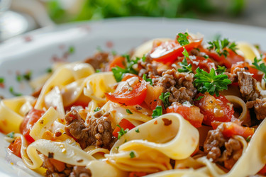 блюдо из пасты с помидорами, мясным фаршем и петрушкой, посыпанное пармезаном - yliv