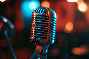 Vintage microphone is standing on stage under blue and red lights - yliv