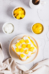 Delicious tiramisu with cookies, mango purée, and cream cheese, served on a plate top and vertical view - Elena Rui