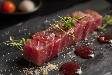 вкуснейшая закуска сашими из тунца, украшенная микрозеленью и семенами кунжута, на грифельной тарелке - yliv