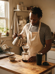 мужчина заваривает и разливает кофе на кухне - artshock