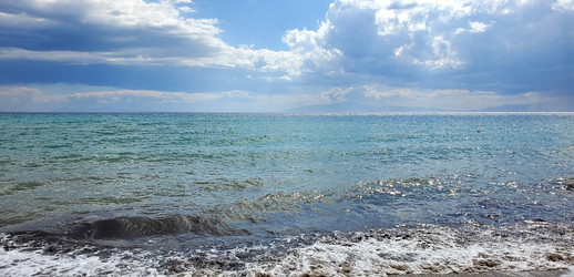 береговая линия моря после шторма. маленькие волны и солнце с облаками - Dimasik_85