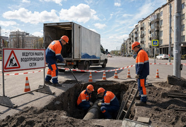Коммунальщики ремонтируют водопроводную трубу в яме на городской улице - brillenstimmer