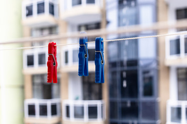 Plastic clothespins hang on rope close-up in city - vale