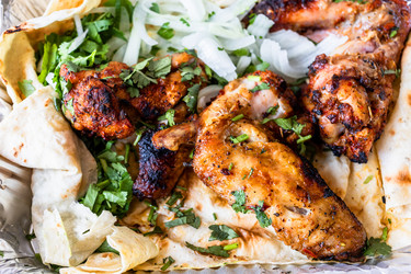 Куриные крылышки-гриль крупным планом с нарезанным луком - vale