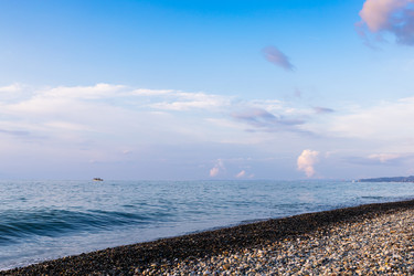 Темно-синее небо, морская вода и галечный пляж в сумерках - vale