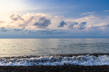 вид на прибой морской воды и низкие облака в сумерках - vale