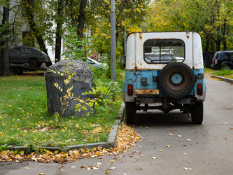 Старый ржавый внедорожник УАЗ-469 припаркован в осеннем городском дворе - raregarden