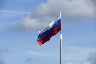 Флаг Российской Федерации, освещенный солнцем, развевается под голубым небом - Vorchun